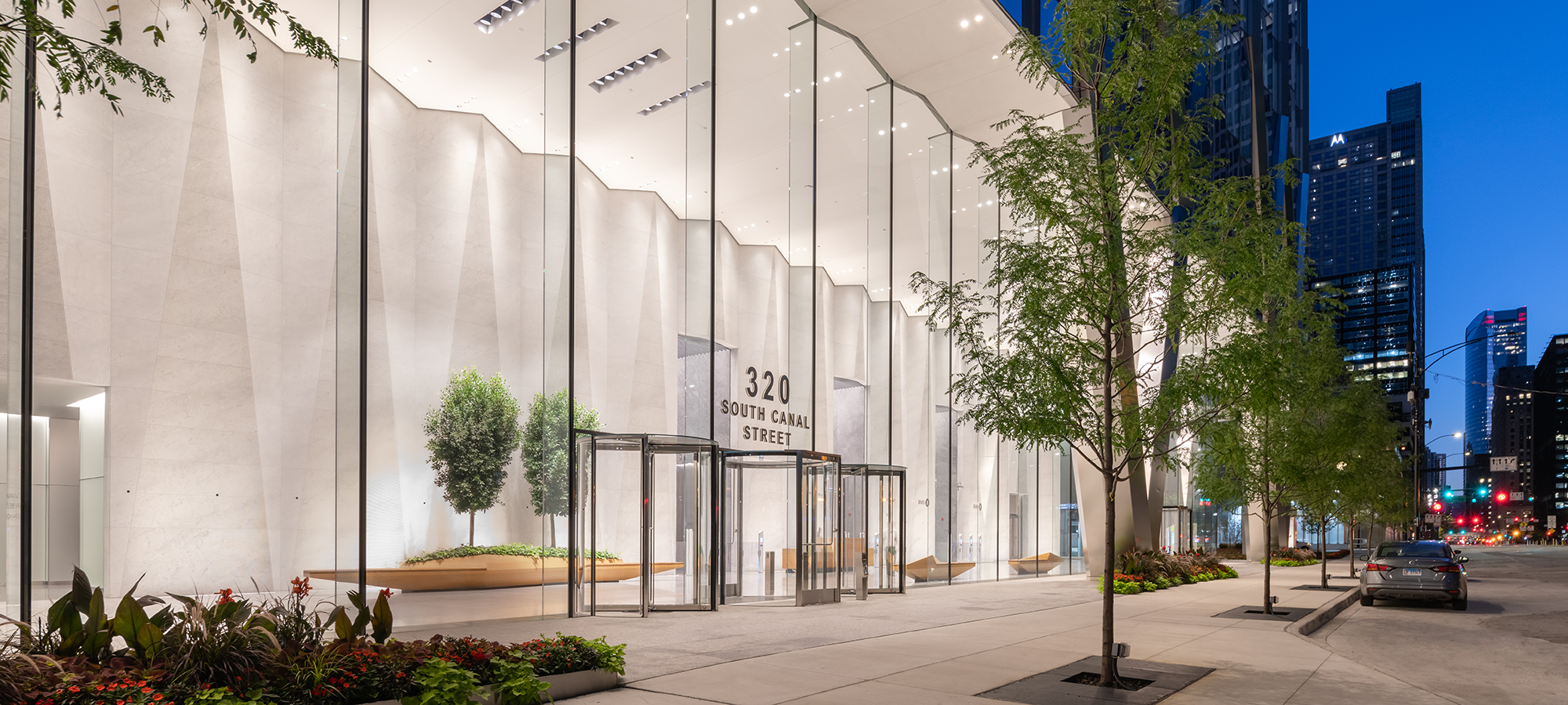 A office building lobby glowing through its glass facade at night