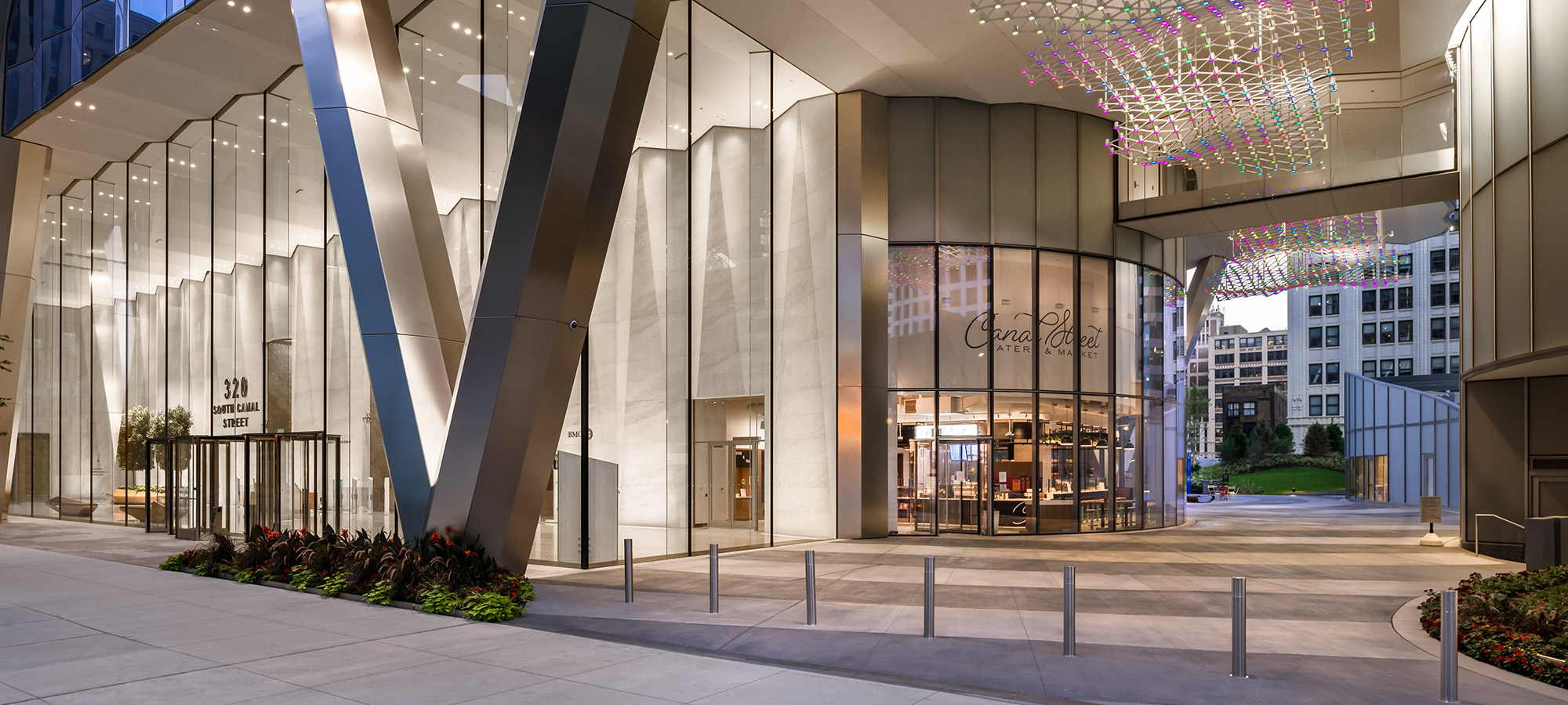 A glass outdoor entrance into a modern office building and eatery